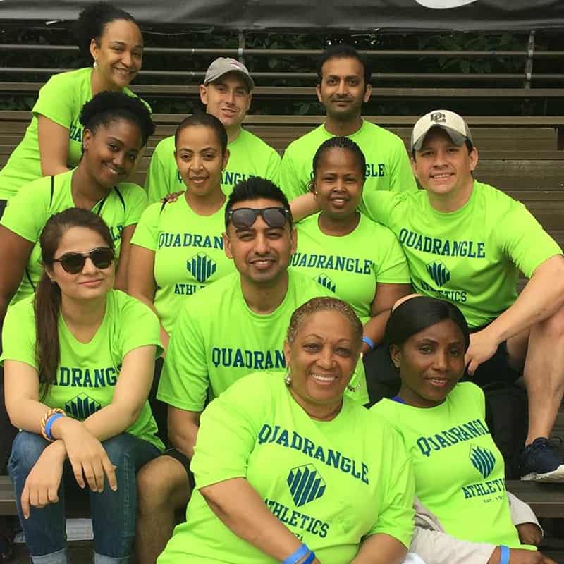 Employees group photo, with people smiling in green shirts